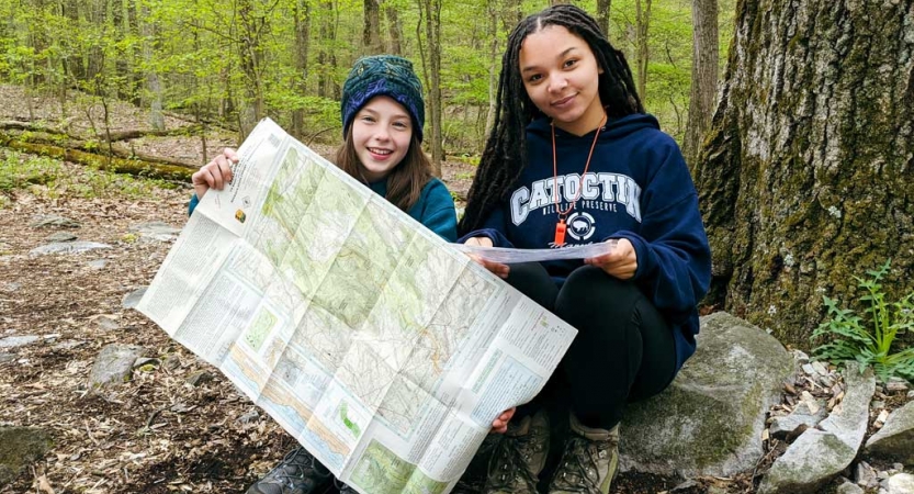 two girls practice navigation skills on a trip with outward bound